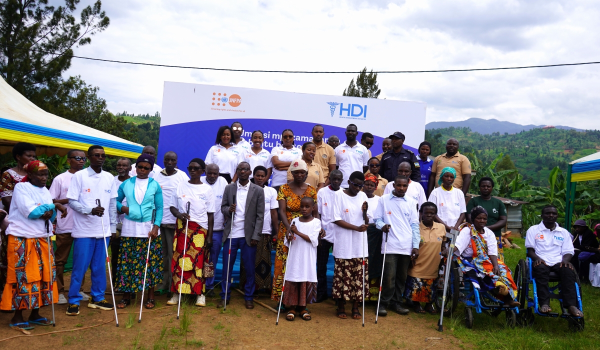 A group of people with disabilities stand in front of the HDI banner during International Day of People with Disabilities, which was observed in Nyamasheke District