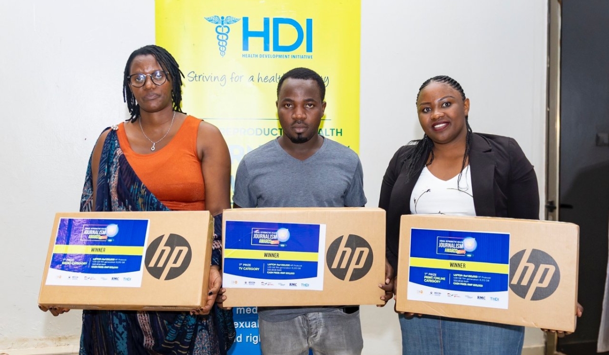 Three winners from HDI's journalism awards stand holding their prizes: new HP laptops.